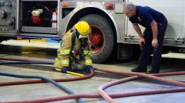 Student Abby Stezenko learns how to find her way out of a burning building by following the fire hose back