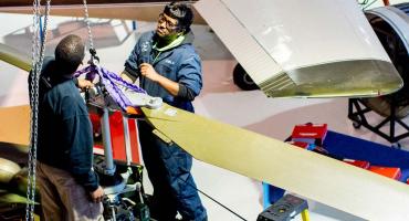 photo - Aircraft Maintenance students removing a helicopter blade