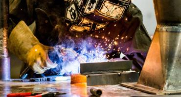 photo - welding student practicing a welding bead in one of our modern welding booths