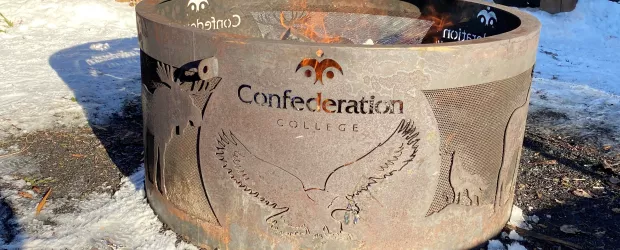 Fire pit with Confederation College logo