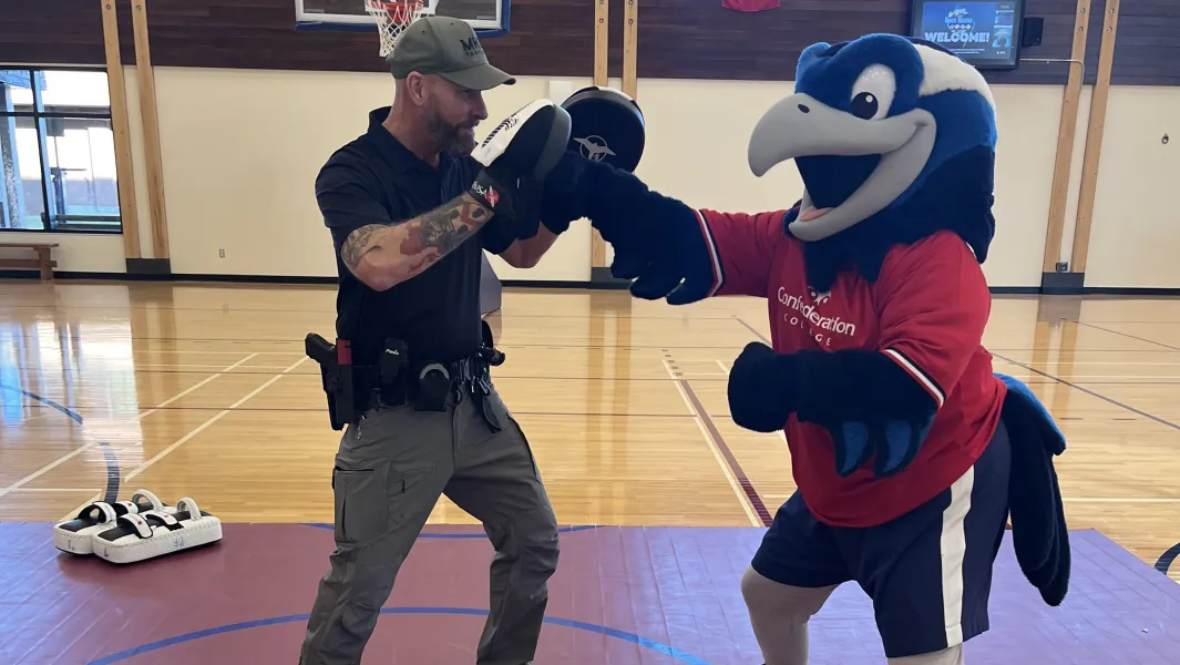 College mascot practices boxing drills with a police instructor