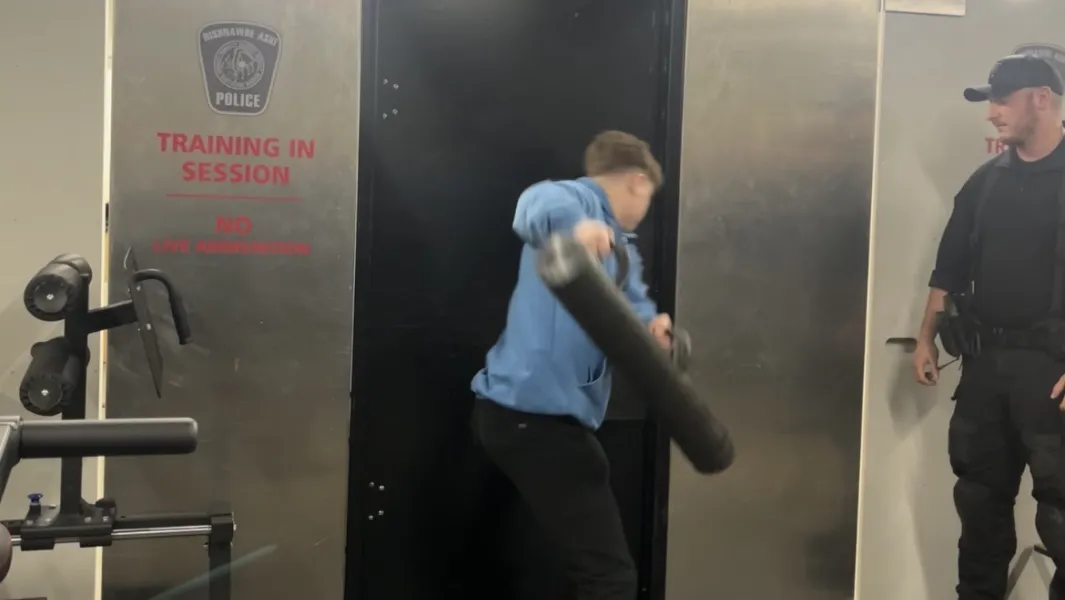 Trainee practices forced entry using a battering ram during police training