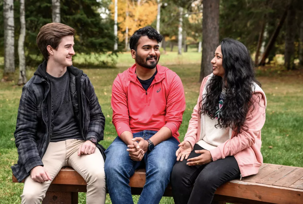 Three college students of diverse backgrounds on campus