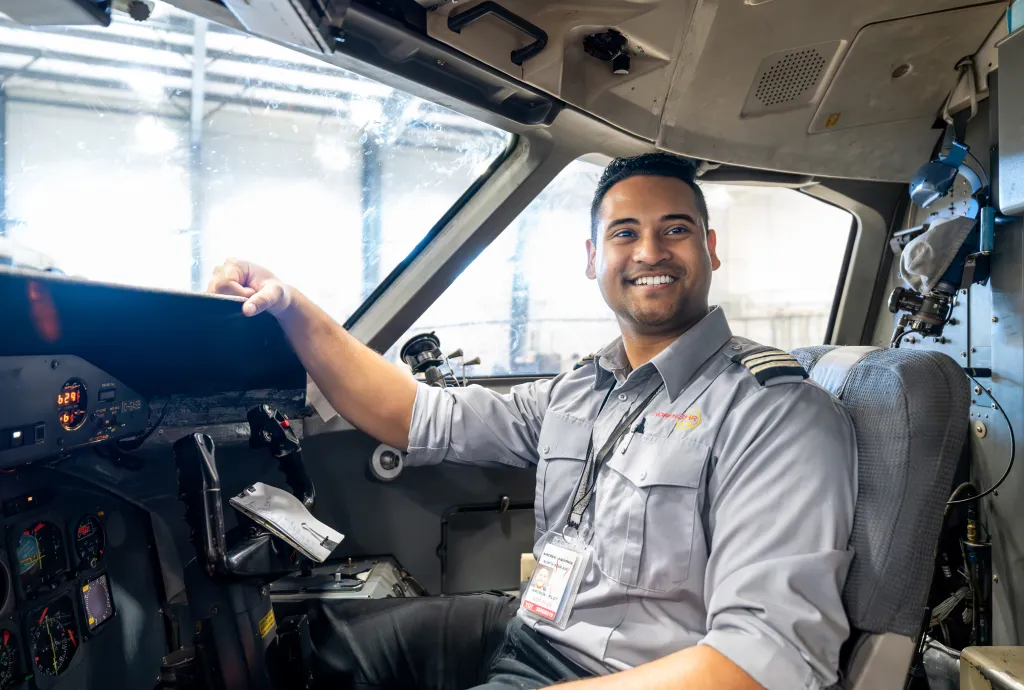 Aviation Flight Management graduate in cockpit of Dash 8, representing path to first officer with North Star Air.