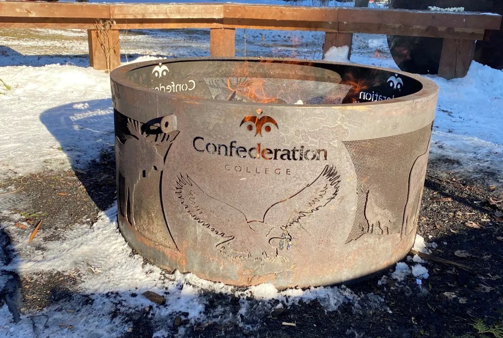 Fire pit with Confederation College logo