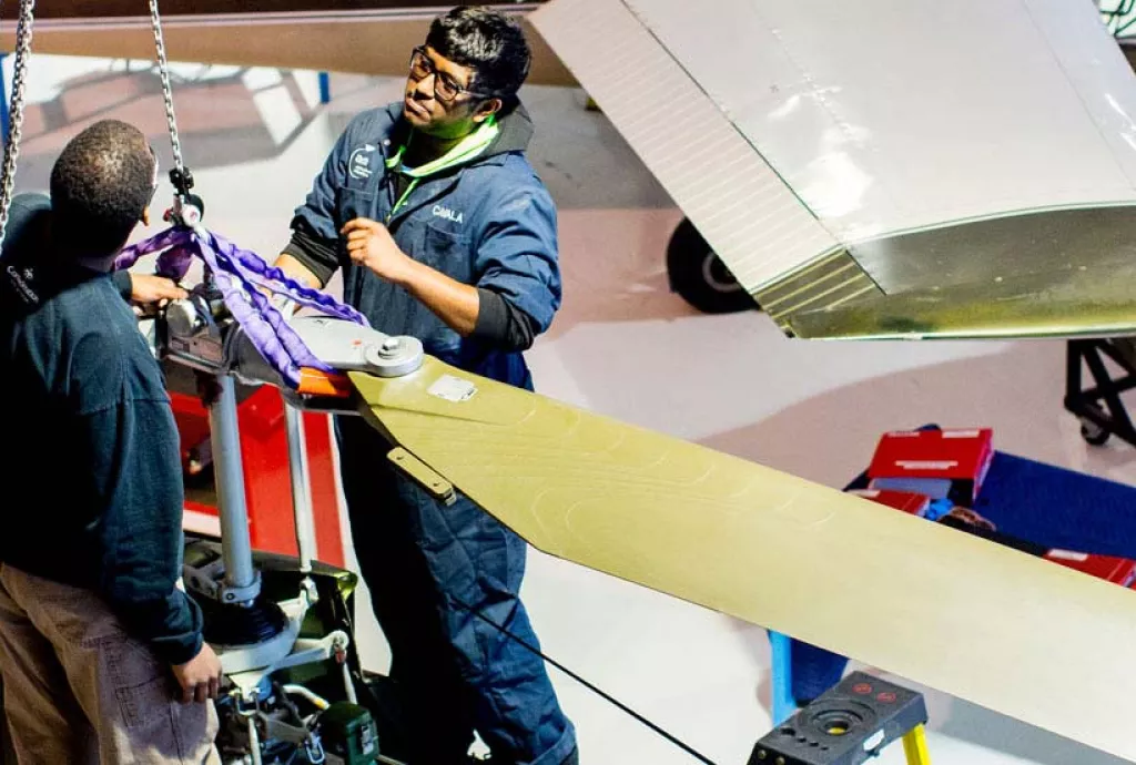 photo - Aircraft Maintenance students removing a helicopter blade