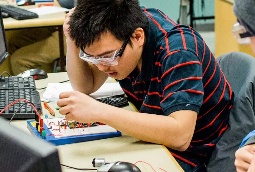 banner photo - international student working in electronics lab