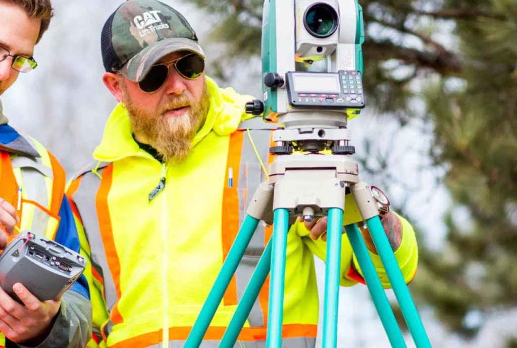photo - Civil Engineering students practicing their use of a modern digital transit in the field