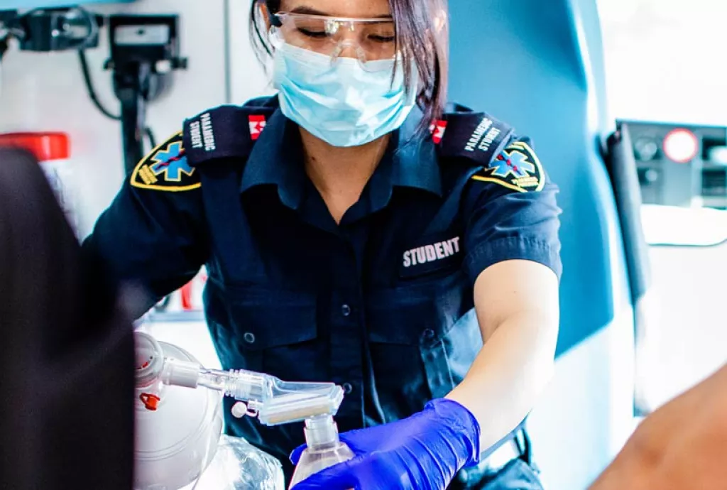 photo - Paramedic students practicing their skills in a mock ambulance