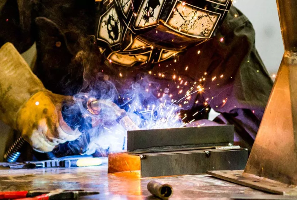 photo - welding student practicing a welding bead in one of our modern welding booths